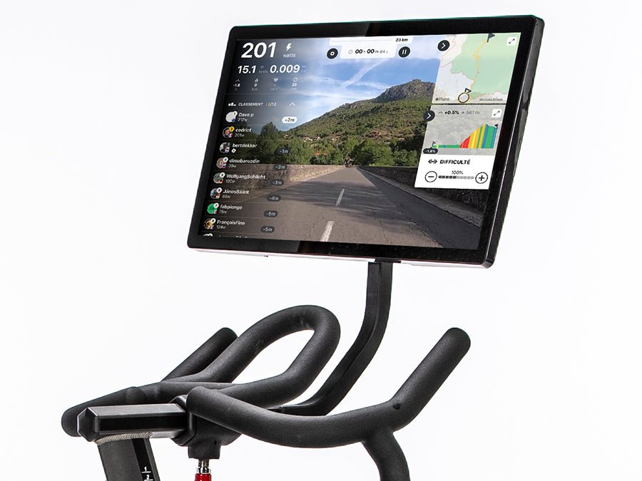 Connect-22 tablet mounted on a BodyCraft indoor cycle, displaying a scenic road in a rural setting with hills and trees on the screen.