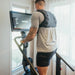 Male athlete working out on the STEPR+ Stair Climber at home, backside view, showing the compact design fitting easily into a residential space.