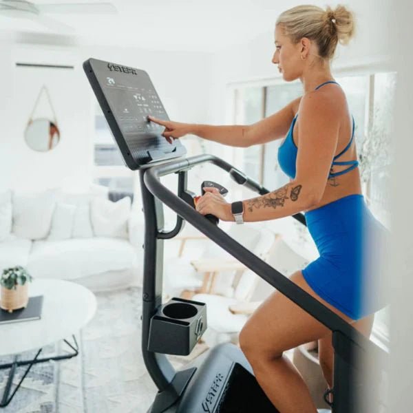 Stepr Classic with woman athlete in her home side view interacting with console