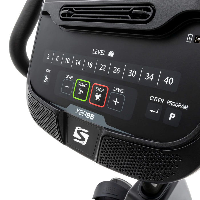 Close-up view of the bottom console of the Spirit Fitness XBR95 Recumbent Bike, displaying built-in Bluetooth speakers, resistance level controls, and direct resistance buttons