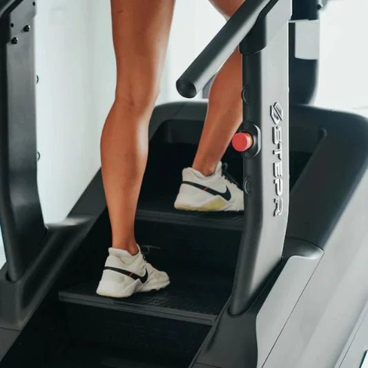 Close-up of the stairs on the STEPR Pro+ Stair Climber, focusing on the athlete's legs and feet engaging with the 7" floating steps.