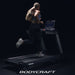 Bodycraft T800 Treadmill on a black background showing a female athlete running