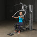Female athlete midway through chest press on Body-Solid G5S Home Gym, arms bent at 90 degrees.