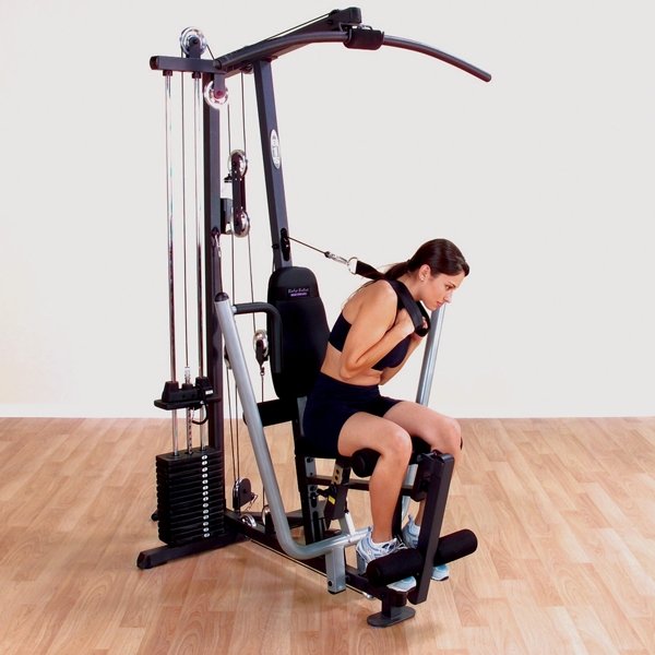 Female athlete performing an ab crunch with the included strap on a Body-Solid G1S Multi-Station Home Gym, targeting core muscles for enhanced abdominal strength.